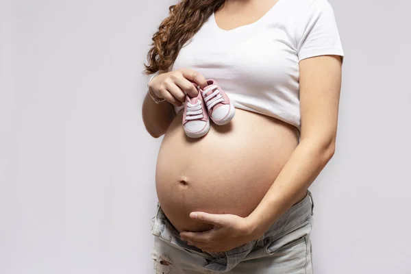 Gros Plan De La Femme Enceinte Avec Des Chaussures De Bebe Sur Le Ventre Soins Jeune Stock Photo Gros Plan De La Femme Enceinte Avec Des Chaussures De Bebe Sur Le Ventre Soins Jeune Stock Photo