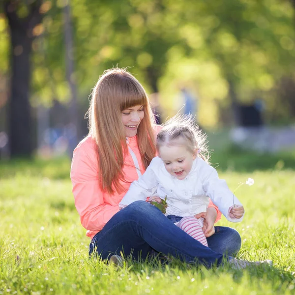 母亲和女儿在公园里 美自然场景丰富多彩的背景 在春暖花开的季节 家庭的户外生活方式 幸福的女人 可爱的女孩在绿色草地上放松 — 图库照片