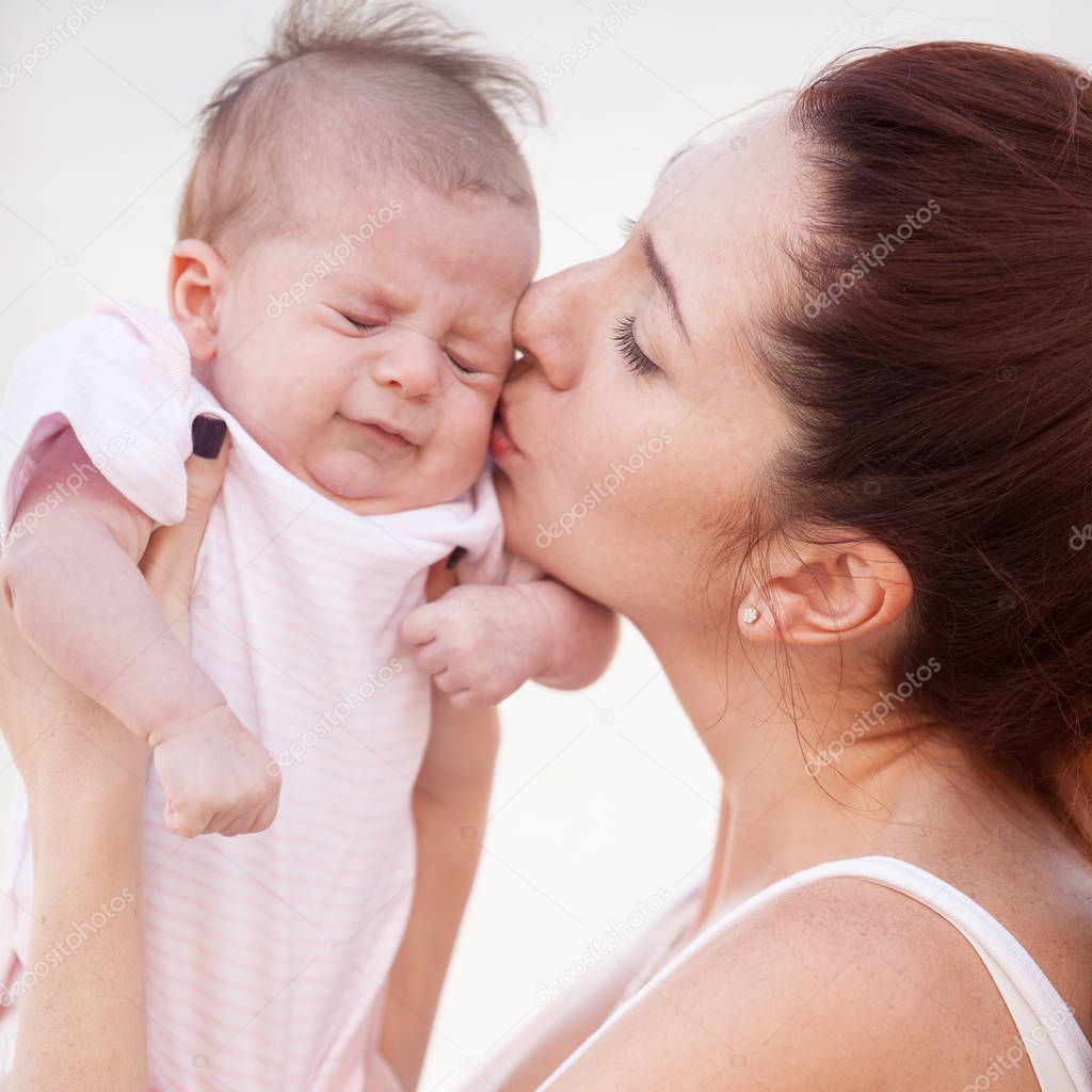 Happy mother kissing her cute baby. Motherhood and children concept