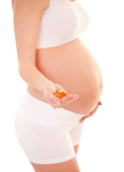 妊娠中の女性は 白い背景で隔離の丸薬を保持しています 栄養と食事は妊娠中 健康的なライフ スタイル 期待の人々 妊娠や母性の概念 — ストック写真