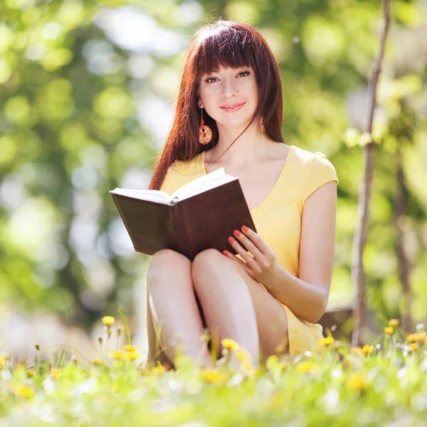 Giovane Donna Che Legge Libro Nel Parco Con Dei Fiori — Foto Stock