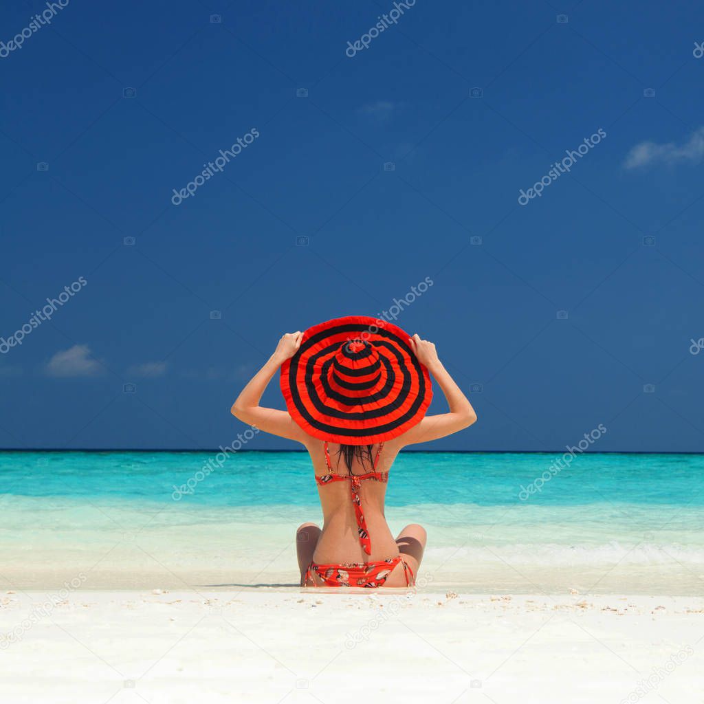 Young fashion woman relax on the beach. Happy lifestyle. White sand, blue sky and crystal sea of tropical beach. Vacation at Paradise. Ocean beach relax, travel to islands