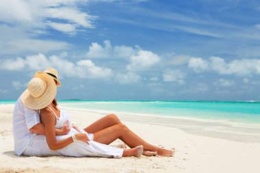Mutlu balayı tatil cenneti. Çift plaj beyaz kum üzerinde rahatla. Mutlu deniz yaşam tarzı. Genç Aile, erkek ve kadın okyanus plaj üzerinde bekletin. Aşık çift adaya seyahat. Aşk seyahat
