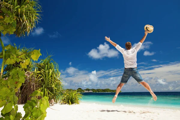 幸せな男は 熱帯のビーチでジャンプします 白い砂 青い曇り空と熱帯のビーチのクリスタルの海 楽園での休暇 幸せな島の生活 オーシャン ビーチ リラックス モルディブ諸島への旅行 — ストック写真