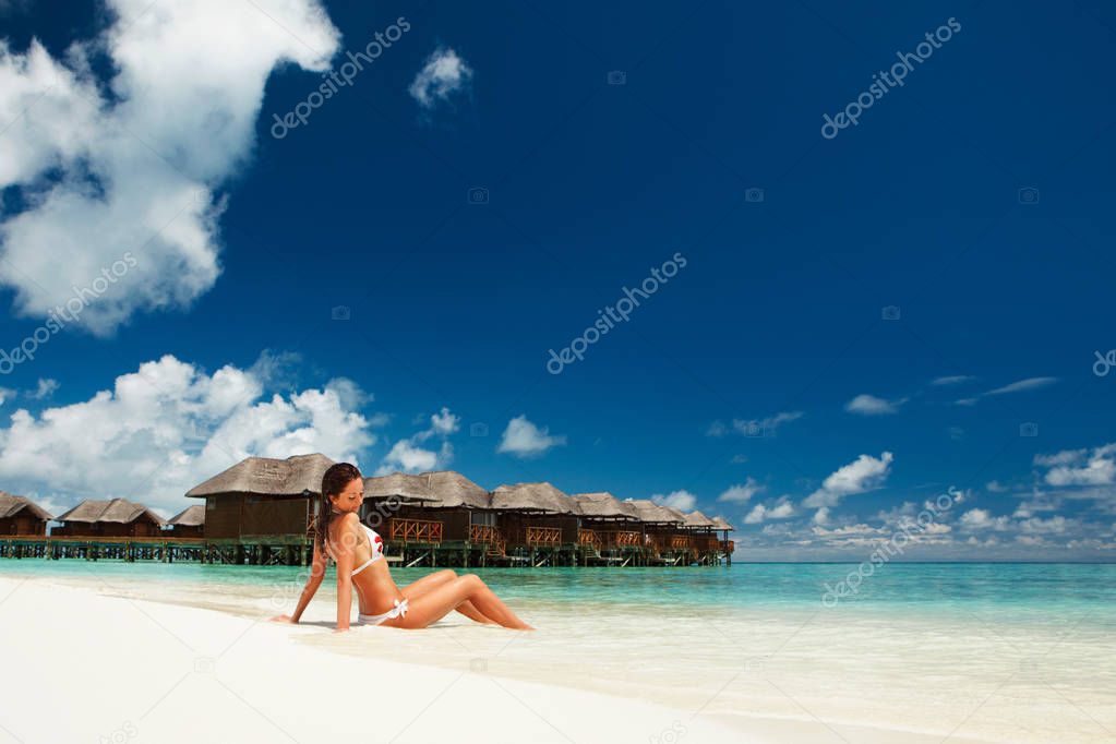 Sexy woman relax on the summer beach. Happy lifestyle. White sand, blue sky and crystal sea of tropical beach. Vacation at Paradise. Ocean beach relax, travel to islands