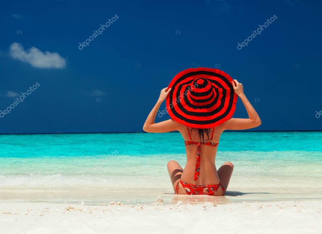 Young fashion woman relax on the beach. Happy lifestyle. White sand, blue sky and crystal sea of tropical beach. Vacation at Paradise. Ocean beach relax, travel to islands