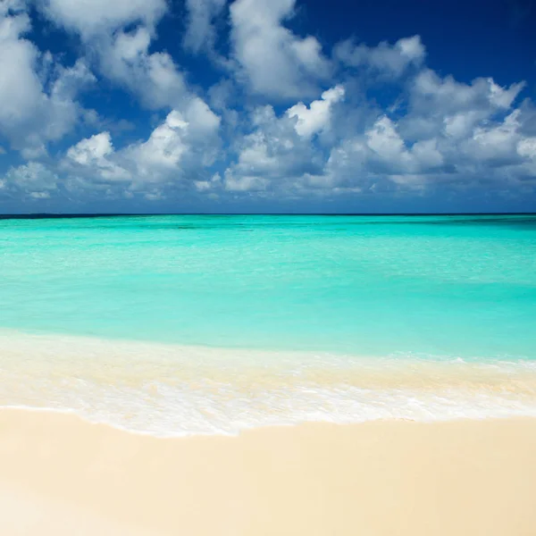 Praia tropical. Ondas oceânicas e céu nublado. Branco san — Fotografia de Stock