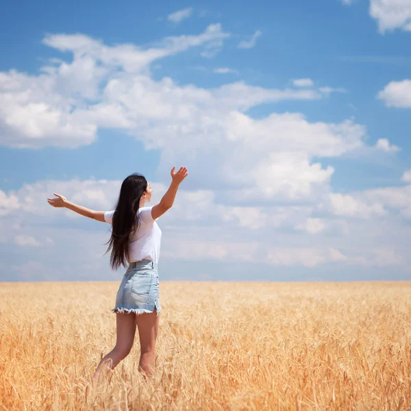 Mujer feliz disfrutando de la vida en el campo Belleza de la naturaleza, cielo azul y campo con trigo dorado. Estilo de vida exterior. Concepto de libertad. Mujer salto en el campo de verano —  Fotos de Stock