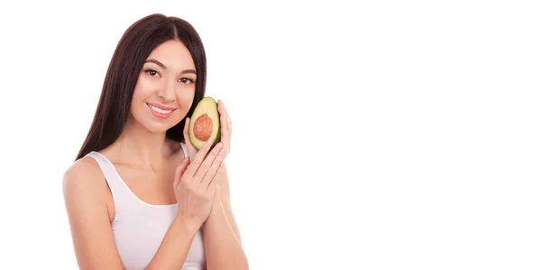 Mujer linda con hermosa sonrisa sosteniendo aguacate. Vida sana y nutrición, dieta, pérdida de peso, cosmetología, cuidado dental y consepto dental saludable. Primer plano retrato de mujer hermosa aislada sobre fondo blanco —  Fotos de Stock