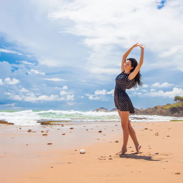 Mujer de moda caminando por la playa. Feliz estilo de vida. Arena, cielo azul nublado y olas oceánicas. Vacaciones en el paraíso. Playa del océano relajarse, viajar —  Fotos de Stock