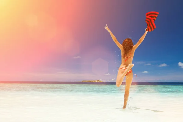 Lycklig ung kvinna hoppar på stranden. Happy Lifestyle. Vit sand, blå himmel, sol och kristall hav av tropisk strand. Semester på Paradise. Ocean Beach Relax, resa till öar. Solljuset — Stockfoto