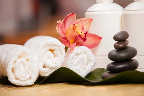 Spa background. White towels on exotic plant, beautiful orchid flower and balancing stones for relax spa massage and body treatment. Asian medicine with aroma and stone therapy for beauty healthy body — Stock Photo, Image