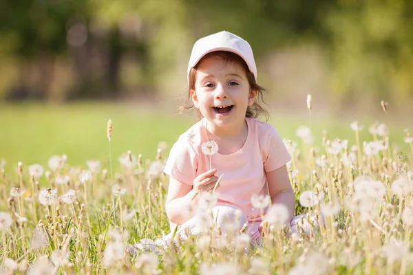 可爱的小女孩在公园里玩耍。夏天或春天,美丽的自然景观,背景五彩斑斓.家庭户外生活方式。快乐的女孩在绿草上休息 — 图库照片