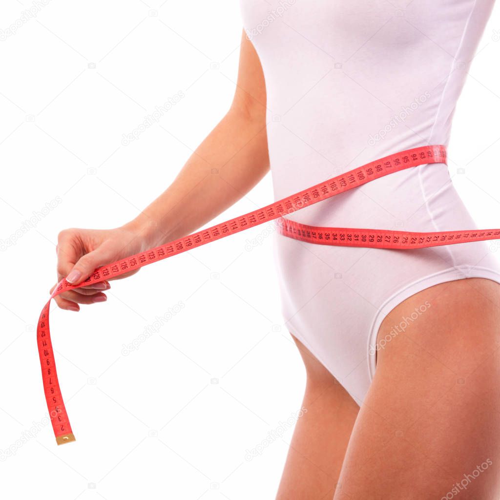 Woman body with measure tape. Close up of sporty and beautiful female body. Tanned woman measuring waist and hips with measuring tape. Healthy lifestyle, dieting, fitness, weight loss concept