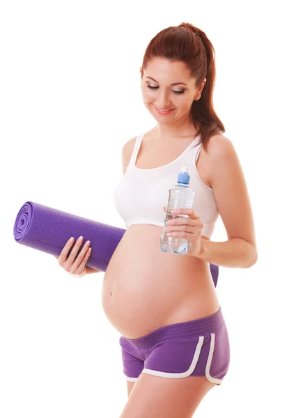 美丽的孕妇行使垫子和白色背景上的水。健康的生活方式。母亲、 怀孕、 人和期望的概念。孕妇怀孕了 — 图库照片