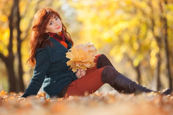 Ung vacker kvinna som kopplar av i höstparken. Skönhet natur scen med färgglada bladverk bakgrund, gula träd och blad på höstsäsongen. Höst utomhus livsstil — Stockfoto