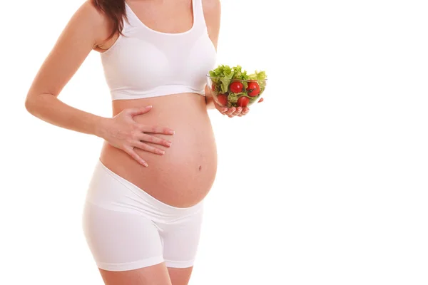 年轻的孕妇拿着沙拉在白色背景下被隔离。怀孕期间的营养和饮食。健康的生活方式。母性、怀孕、人和期望概念 — 图库照片