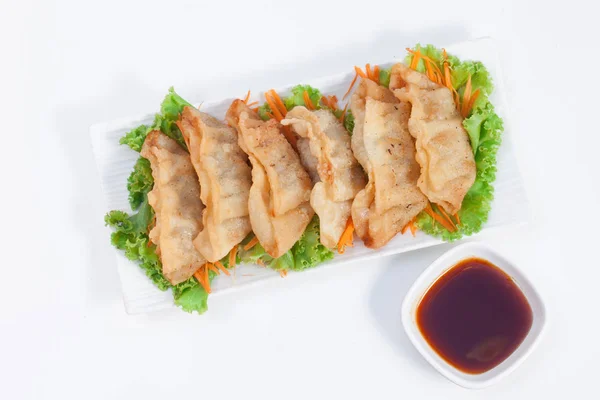 Gyoza A Chinese dish is available on vegetables, salads, lettuce and carrots on white ceramic dishes in white scenes with a sweet, spicy sauce. Pick Up Page