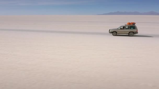 Aerial shot of a 4x4 on Uyuni salar. South of Bolivia. — Stock Video