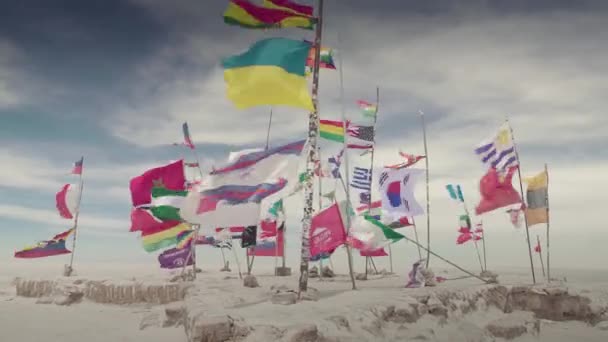ボリビアのウユニ・サラールにおけるアンデスとボリビアの旗としてのダカール世界旗. — ストック動画