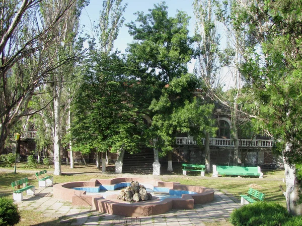Yaşlı malikanenin girişinin önündeki çeşme ve çim