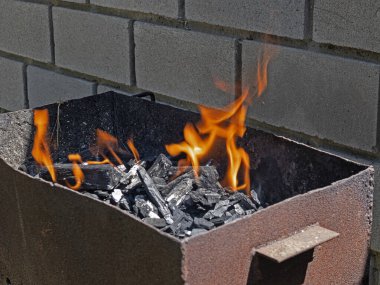 Izgaradaki Yanan Kömürlerin Üzerinde Orange Flame bir çeşit dans yaratıyor. Kebap yapmak için her şey hazır.