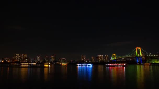 Pływające statki w nocy w pobliżu upływ czasu rainbow bridge — Wideo stockowe