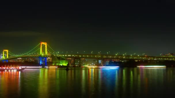 Pływające statki w nocy w pobliżu upływ czasu rainbow bridge — Wideo stockowe