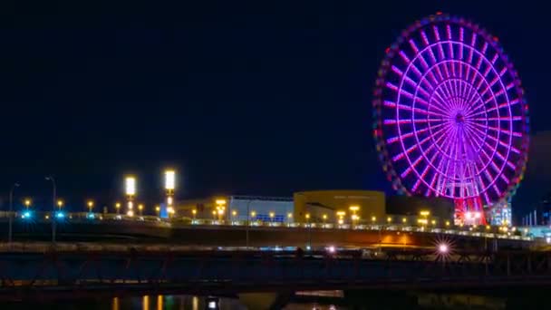 Колесо обозрения возле реки ночью в Одайбе Токийское время истекло — стоковое видео