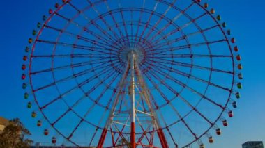 Odaiba Tokyo zaman atlamalı geniş çekim mavi gökyüzü arkasındaki dönme dolabı
