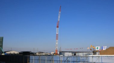 Yapım aşamasında geniş çekim de mavi gökyüzü arkasında hareketli vinçler