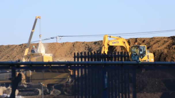 Moving cranes behind the blue sky at the under construction — Stock Video