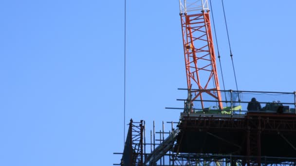Grúas móviles detrás del cielo azul en la construcción bajo — Vídeo de stock