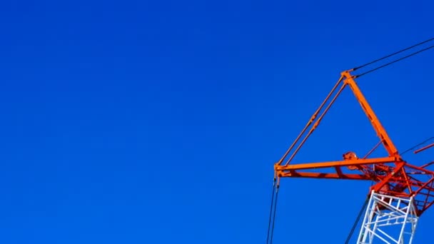 Un lapso de tiempo de grúas móviles detrás del cielo azul en el día en construcción — Vídeo de stock