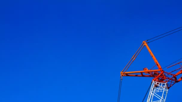 Un lapso de tiempo de grúas móviles detrás del cielo azul en el día en construcción — Vídeo de stock