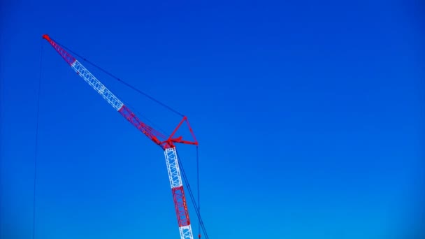 Um lapso de tempo de guindastes em movimento atrás do céu azul em construção durante o dia — Vídeo de Stock