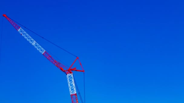 Zeitraffer fahrender Kräne hinter dem blauen Himmel am Tag der Bauarbeiten — Stockvideo