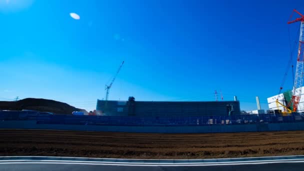 A time lapse of moving cranes behind the blue sky at the under construction wide shot — Stock Video