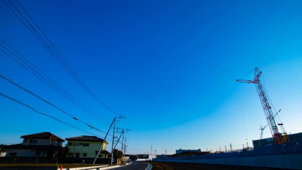 Un laps de temps de grues mobiles derrière le ciel bleu au large plan en construction — Video