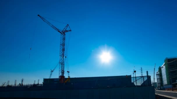 Zeitraffer fahrender Kräne hinter dem blauen Himmel bei der im Bau befindlichen Breitaufnahme — Stockvideo