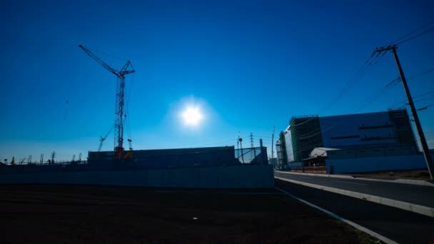 A time lapse of moving cranes behind the blue sky at the under construction wide shot — Stock Video