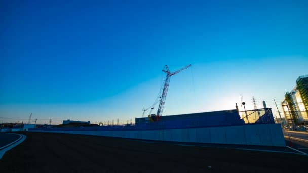 Un laps de temps de grues mobiles derrière le ciel bleu au large plan en construction — Video