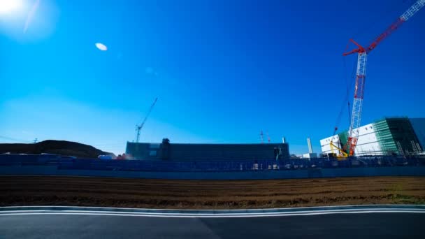 A time lapse of moving cranes behind the blue sky at the under construction wide shot — Stock Video