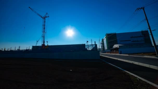 Un laps de temps de grues mobiles derrière le ciel bleu au large plan en construction — Video