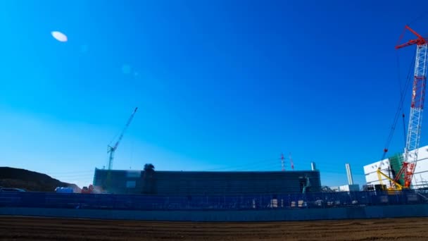 Un laps de temps de grues mobiles derrière le ciel bleu au large plan en construction — Video