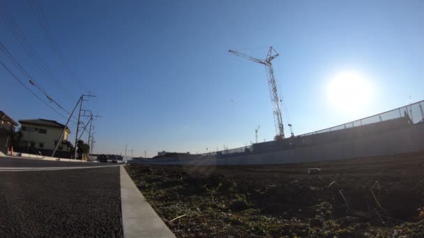 A time lapse of moving cranes behind the blue sky at the under construction wide shot — Stock Video