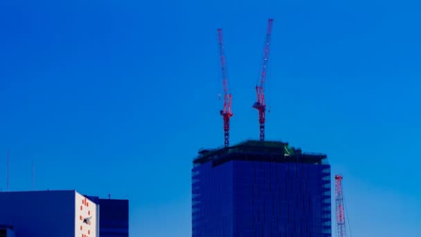 Egy idő telik el a mozgó daruk a tetején épület mögött a kék eget Tokióban — Stock videók
