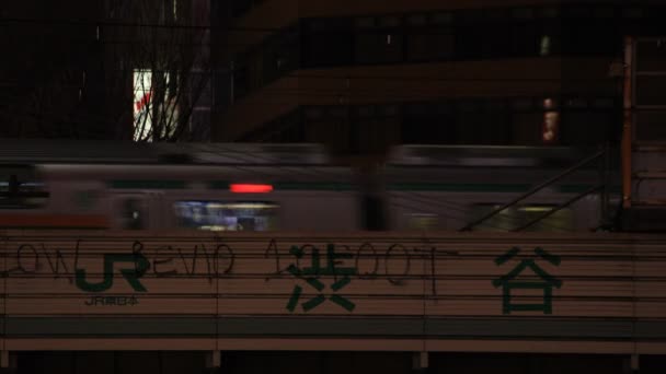 Billboard in de buurt van de spoorlijn in Shibuya Tokyo 's nachts — Stockvideo
