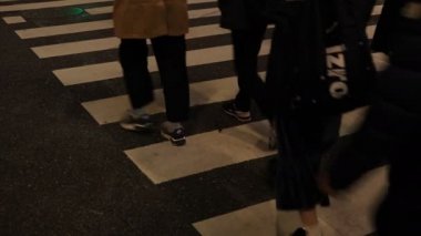 Shibuya geçidinde yürüyen insanların vücut parçaları gece