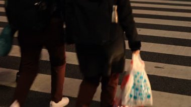 Shibuya geçidinde yürüyen insanların vücut parçaları gece